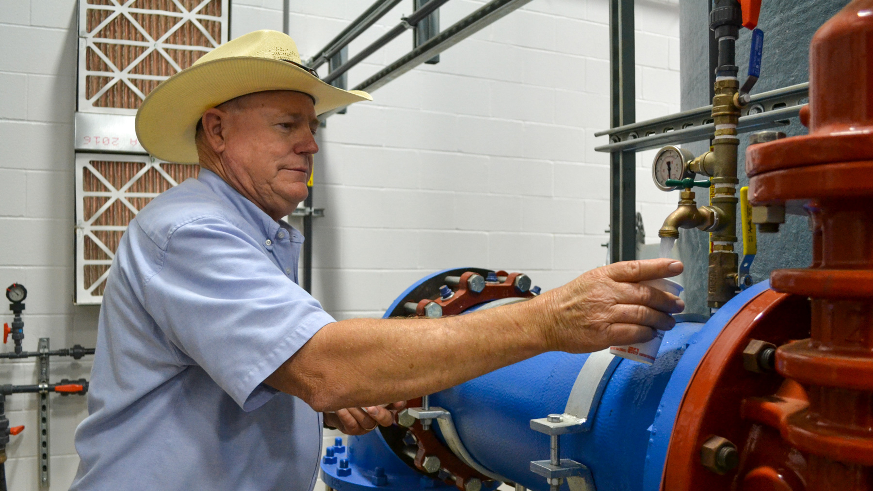 Public Works Director Doug Hutcheson fills a cup with water at the water treatment plant in Wolfforth, Texas. “We've tried to comply. We're team players. We're wanting to fix it and get it on down the road,” he said. (Elizabeth Sims/News21)