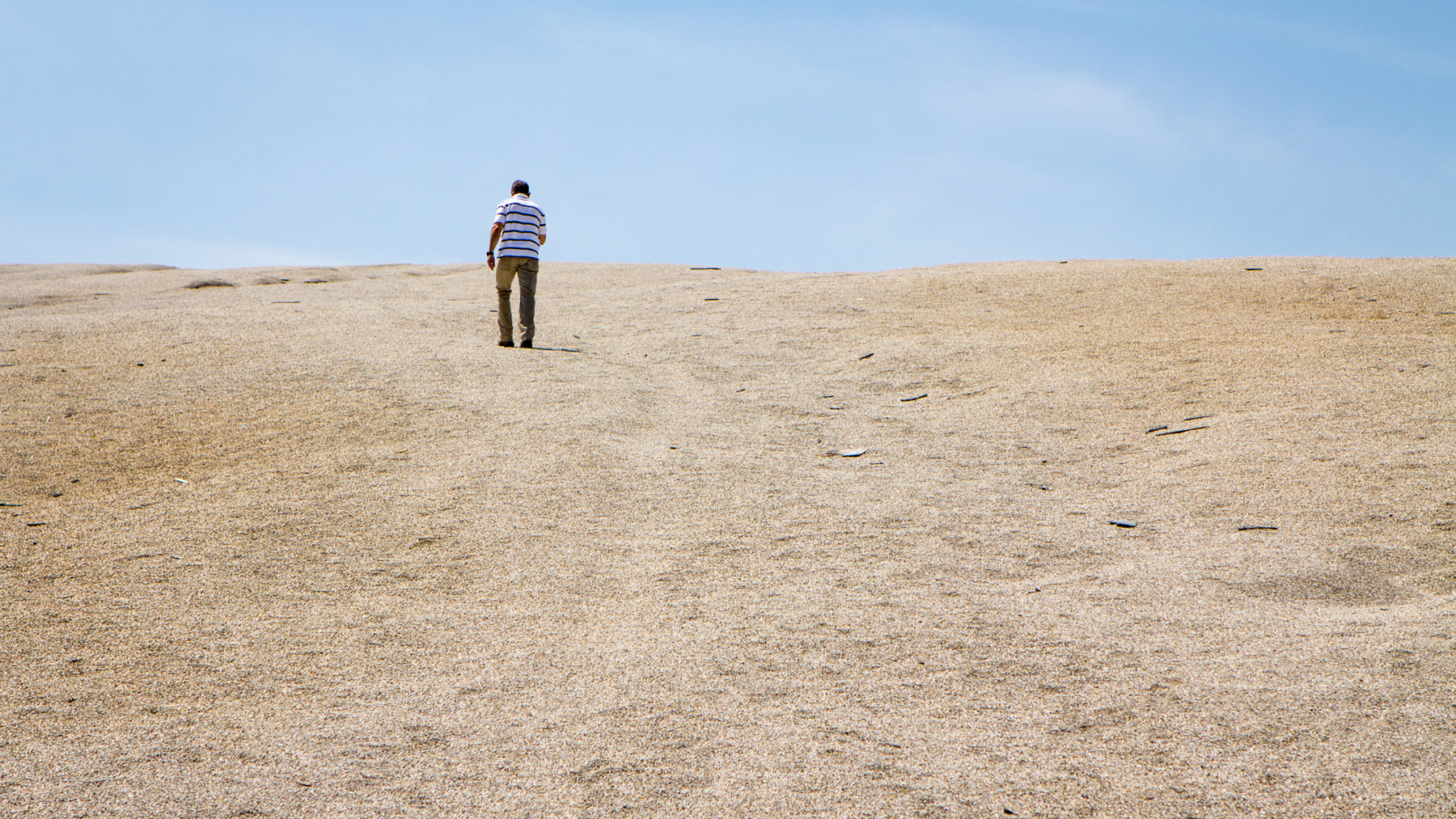 Tim Kent, environmental director of the Quapaw tribe, climbs to the top of a pile of mine waste in Picher, Okla. Chat piles litter the landscape there, and Kent said cleanup could take another hundred years at the current rate. (Jasmine Spearing-Bowen/News21)