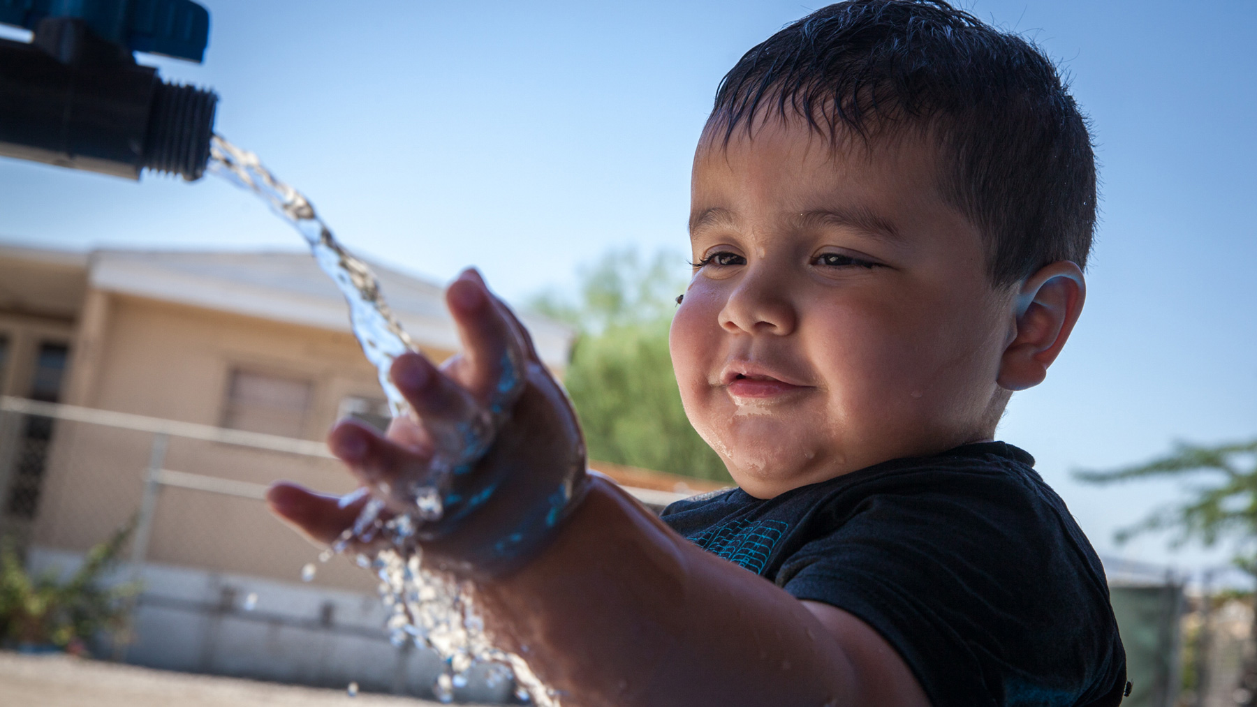 Axel Ruiz, 2, plays with arsenic-contaminated water at his family’s home in St. Anthony Mobile Home Park in California. (Maria Esquinca/News21)